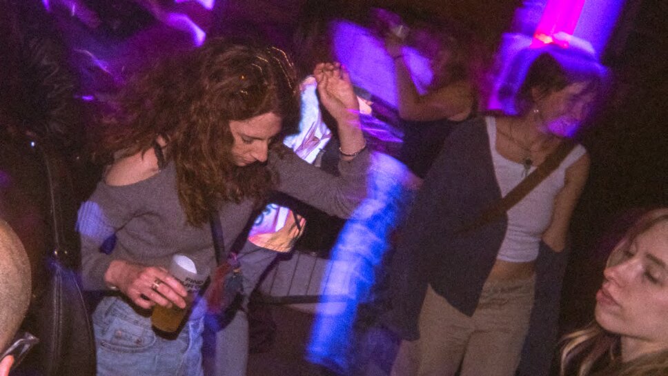 Gente che balla sotto le luci viola a una serata DMHertz al Bloom